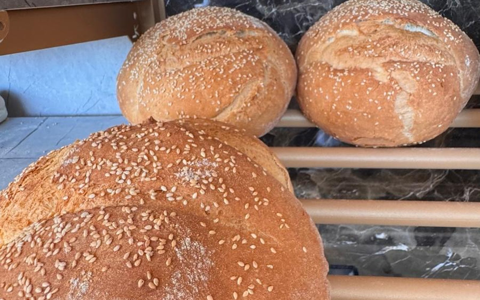 Round sesame-crusted bread loaves fresh from the oven at Bakery Kissamos