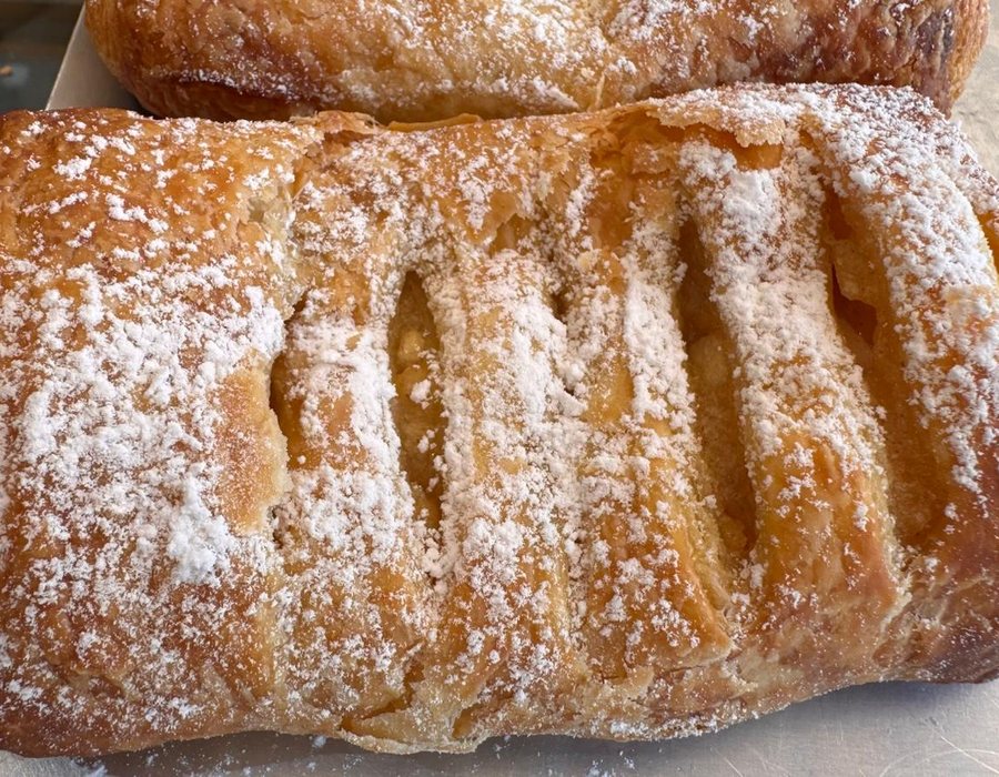 Sweet cream pastry dusted with powdered sugar, traditional pastry Bakery Kissamos